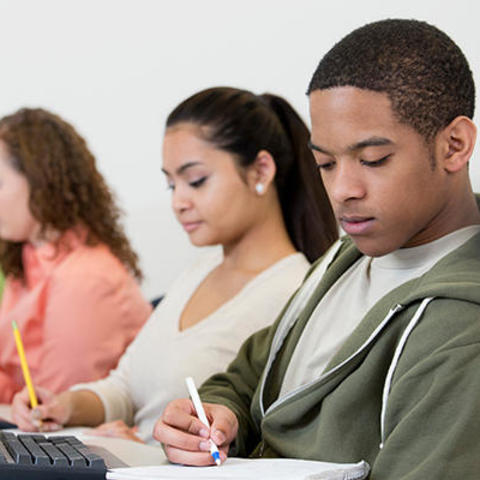 Several students perform class work on laptops and digital pens and paper. 