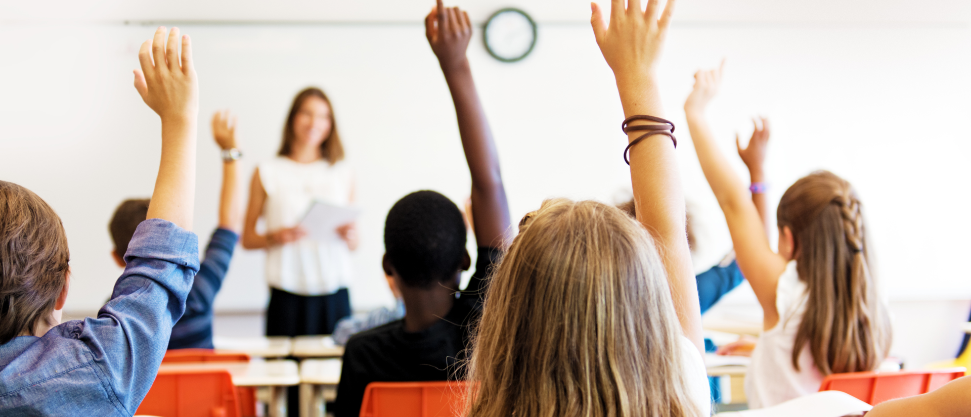 Students raising hand in classroom