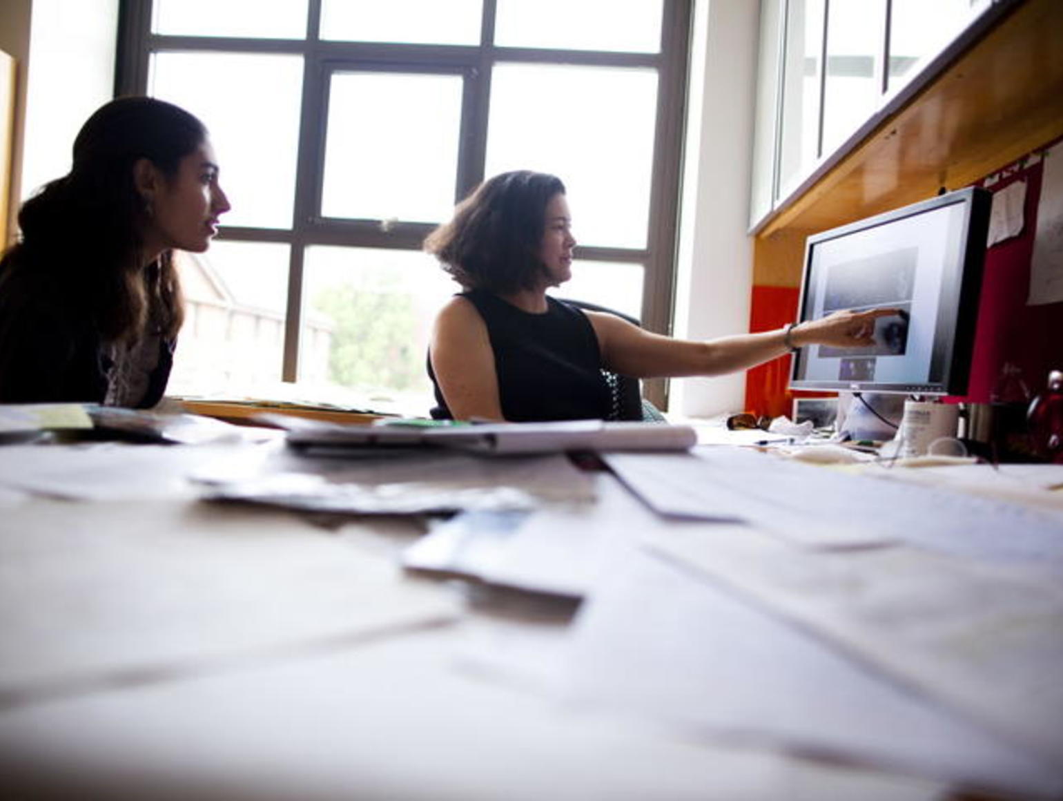 People collaborating in front of a computer