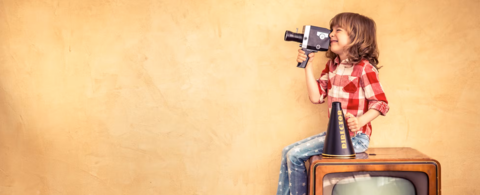 child holding a video camera